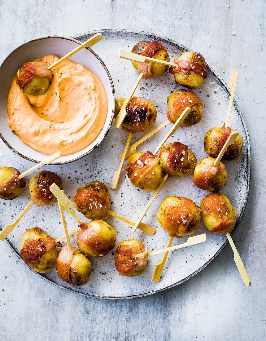 Baby new potatoes wrapped in bacon with harissa cheese dip