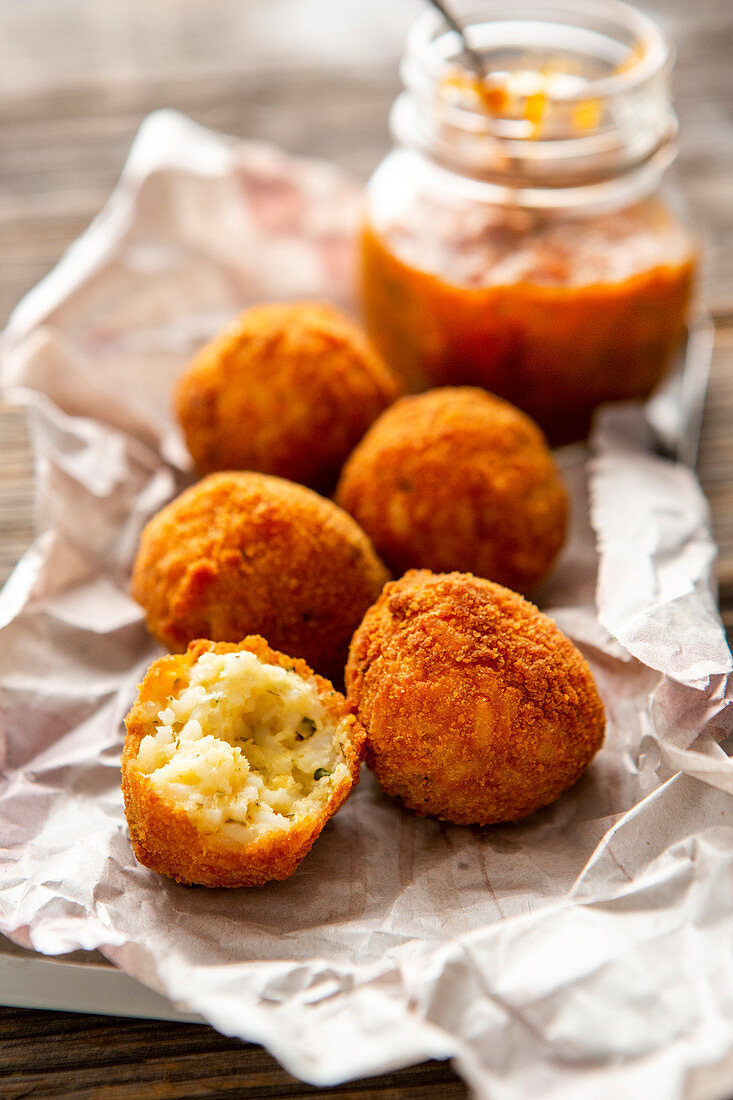 Baked rice balls (arancini) with tomato sauce