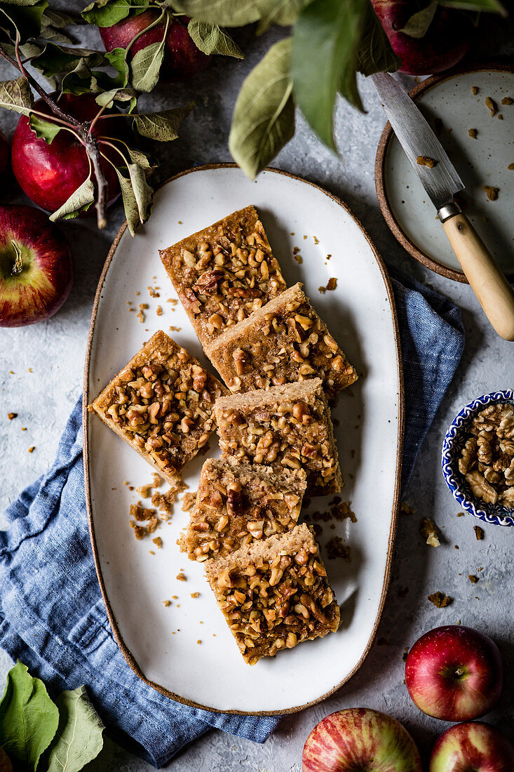 An apple snack cake cut into squares placed on an oval plate