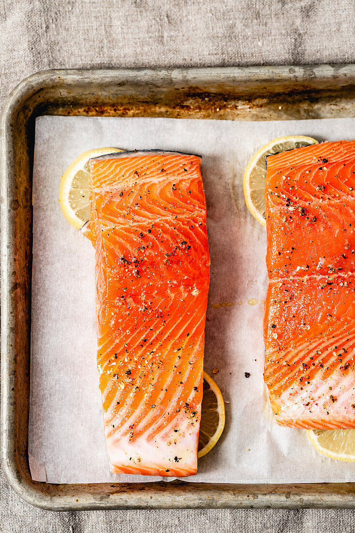 Fresh Salmon in a baking tray, ready for the oven, with slices of lemon