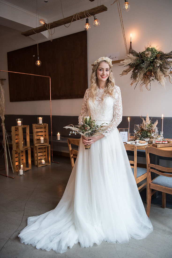 Bride wearing white wedding dress with train in interior with industrial ambiance