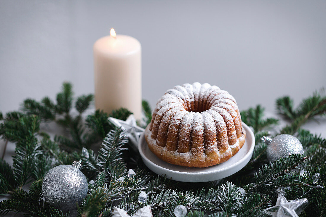 Mini bundt cake sprinkled with powdered sugar on a little cake stand