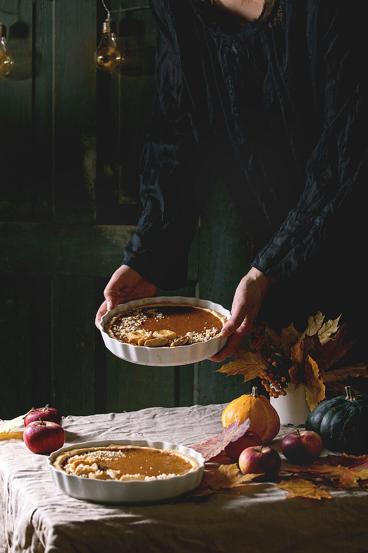 Frau serviert herbstlichen Pumpkin Pie zu Thanksgiving