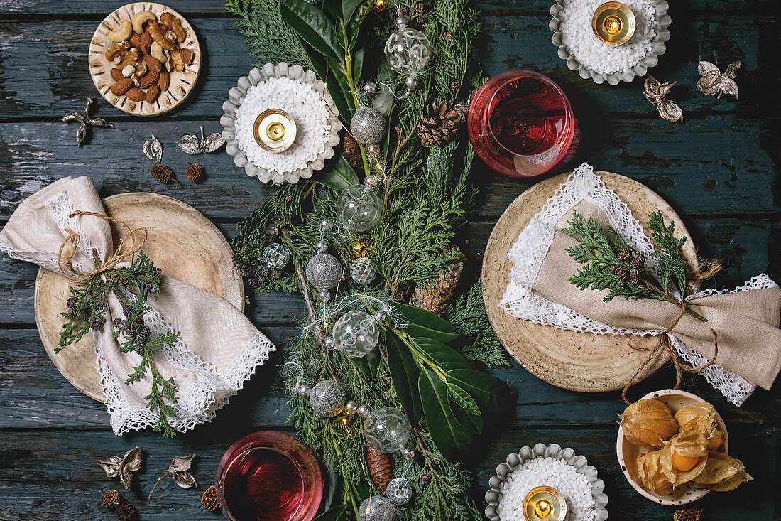 Festlich gedeckter Tisch mit Spitzen-Servietten und Weihnachtsgesteck