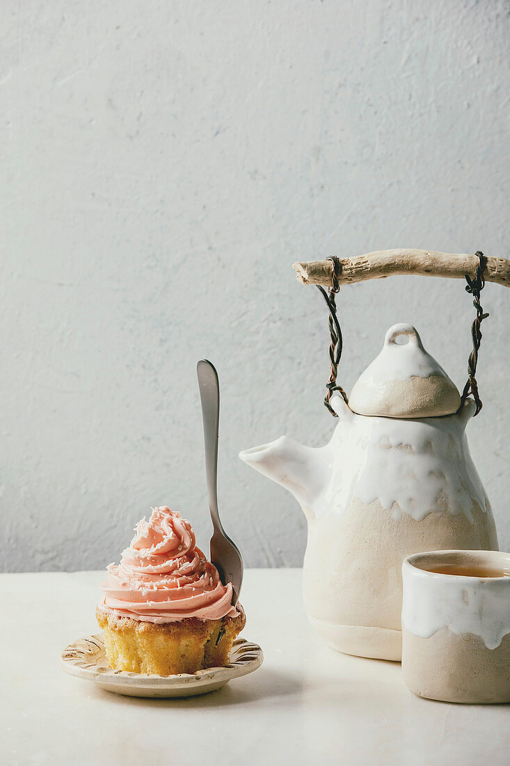 Ein Cupcake mit rosa Buttercreme-Frosting zum Tee