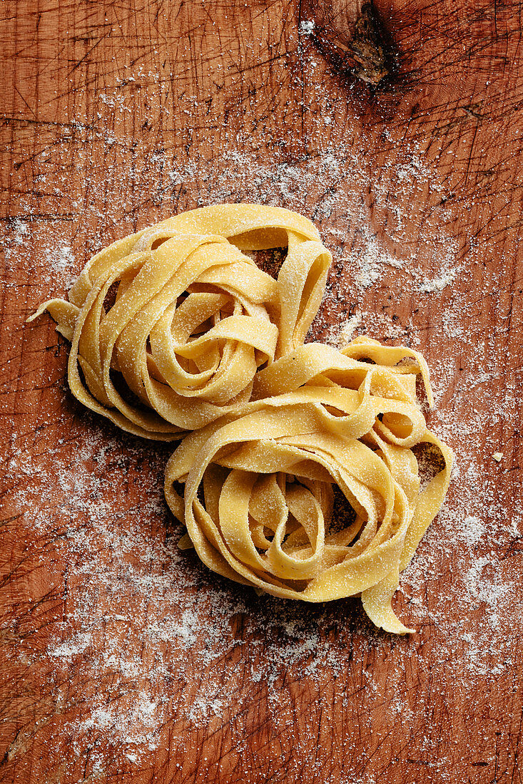 Nest of homemade pasta on wooden board