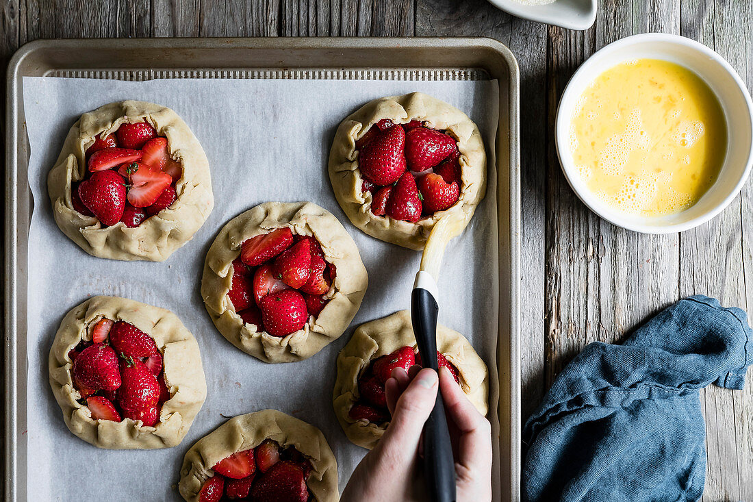 Glutenfreie Galettes mit Balsamico-Erdbeeren und Thymian mit Butter einpinseln
