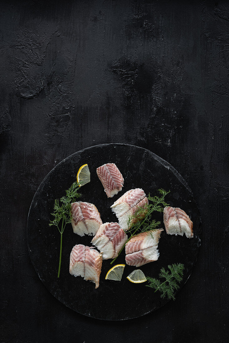 Smoked eel fillet with lemons and dill on a slate plate