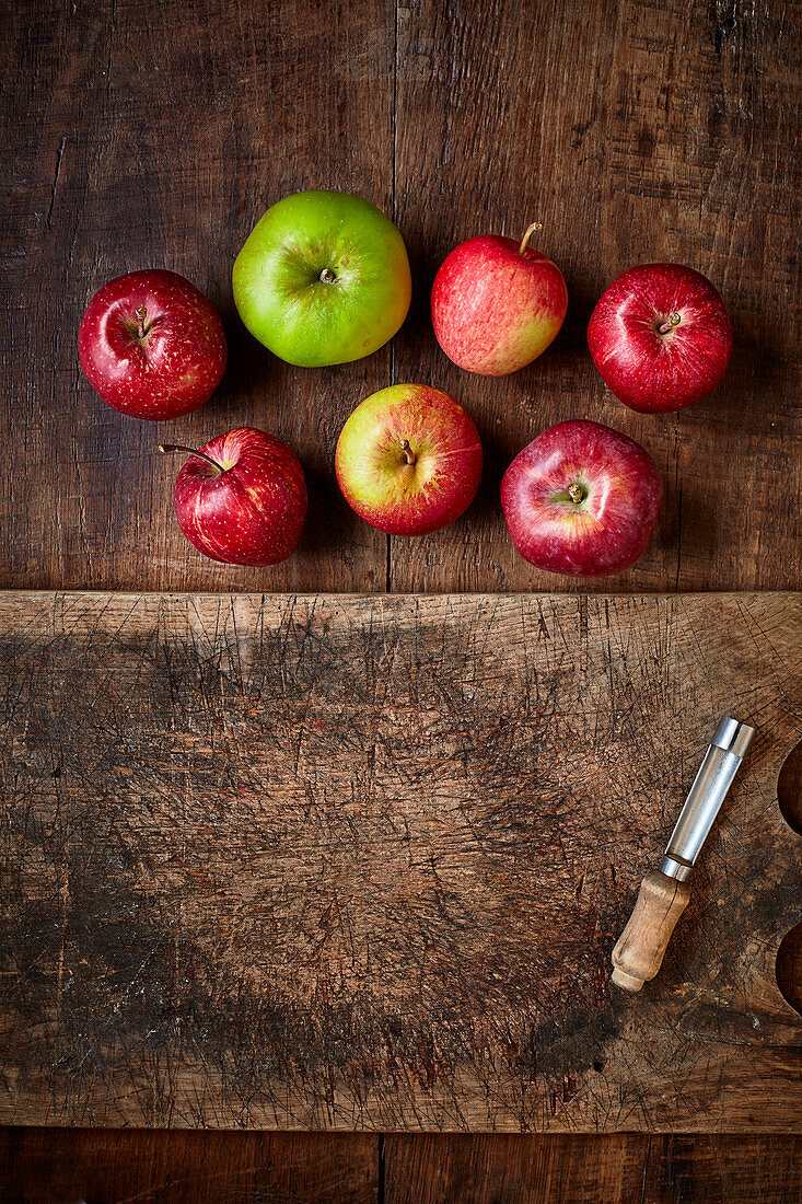 Rote und grüne Äpfel auf Holzuntergrund