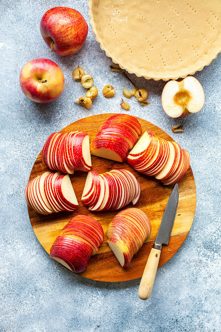 Preparation of an apple tart: Sliced apples on a wooden board