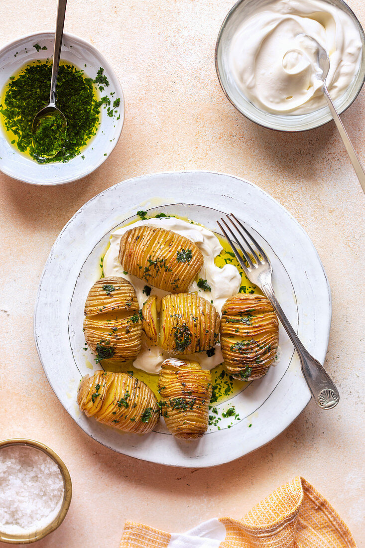 Roasted hasselback potatoes with parsely dressing on a plate