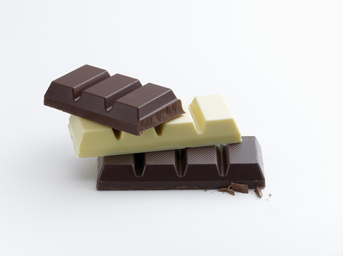 Whole milk, white and dark chocolate couverture on a white background