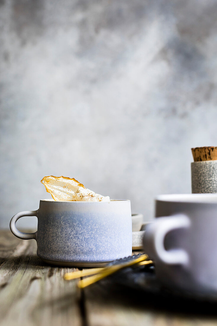 Zimt Latte mit Gewürzen und glasierter Birnenscheibe in Tasse