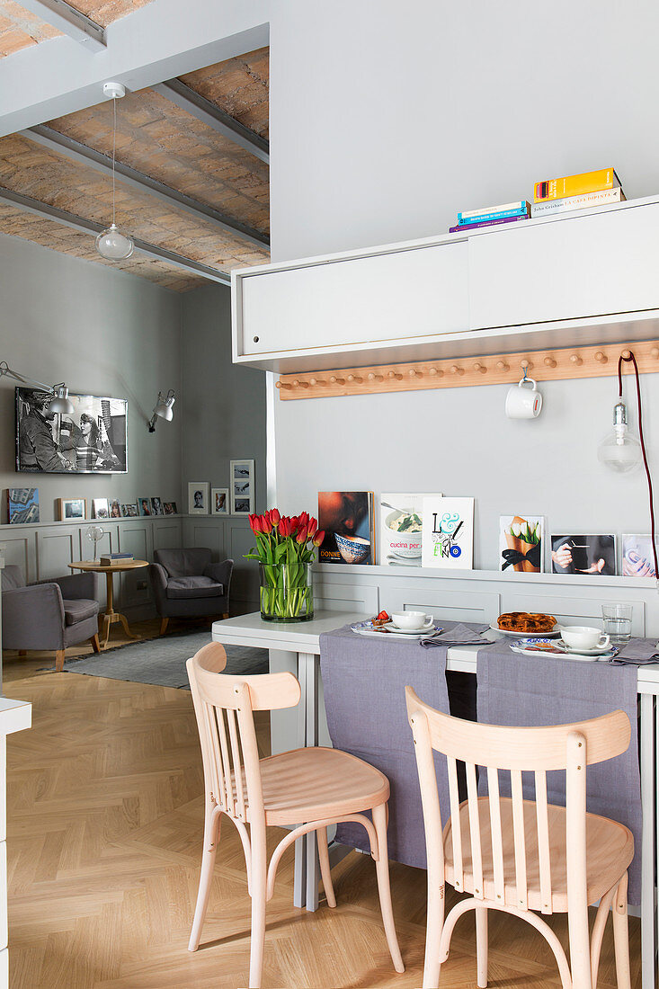 Folding table against wall below row of hooks in small apartment