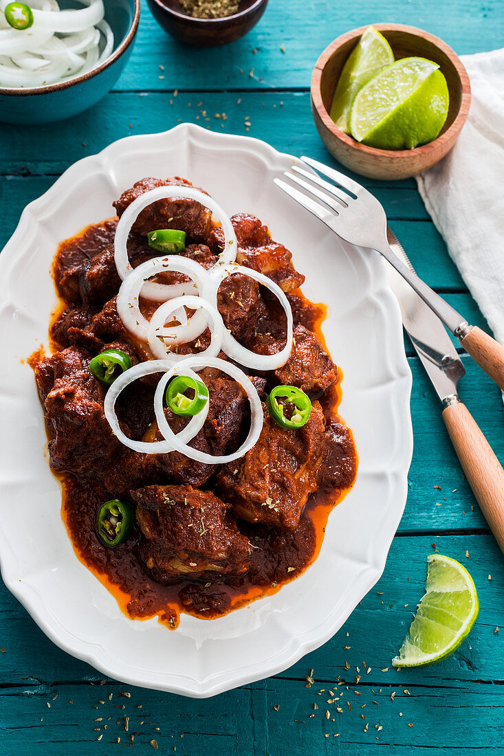 Schweinefleisch in Adobo-Sauce mit Zwiebeln und Chilis