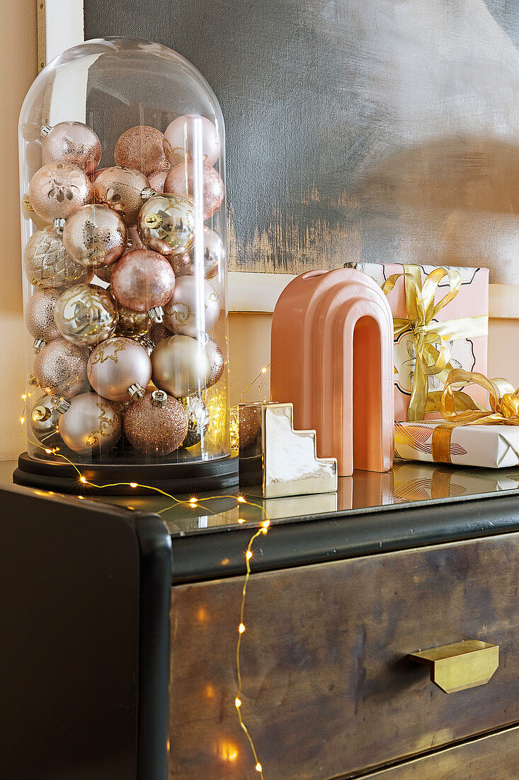 Pink and champagne Christmas baubles under glass cover