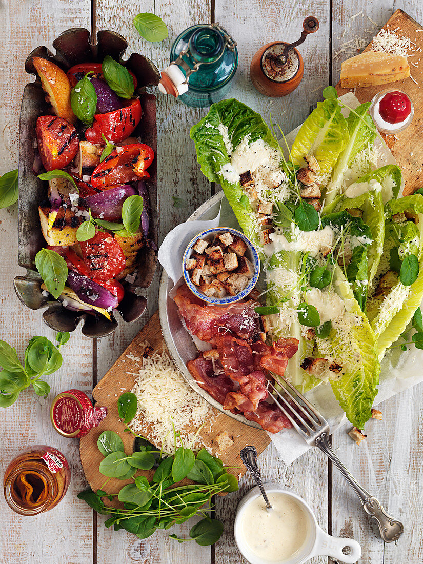 Salat mit gegrilltem Gemüse und Cäsarsalat mit Spinat, Parmesan, Bacon und Croûtons
