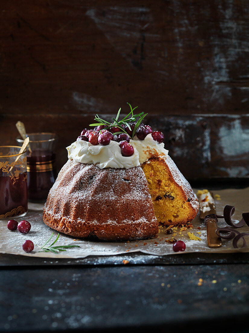 Christmas spongecake with frosting, rosemary icing sugar, saffron and cranberries