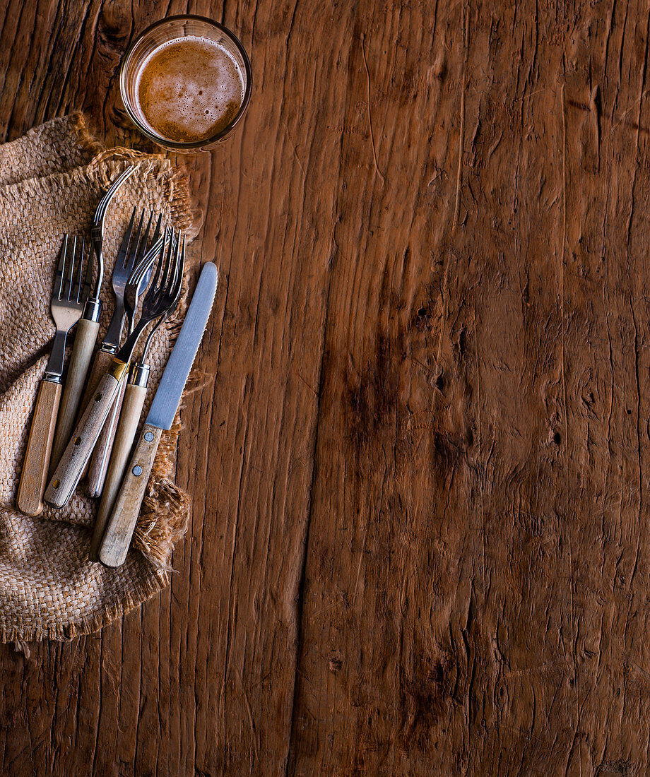 Cutlery and beer on a wooden background
