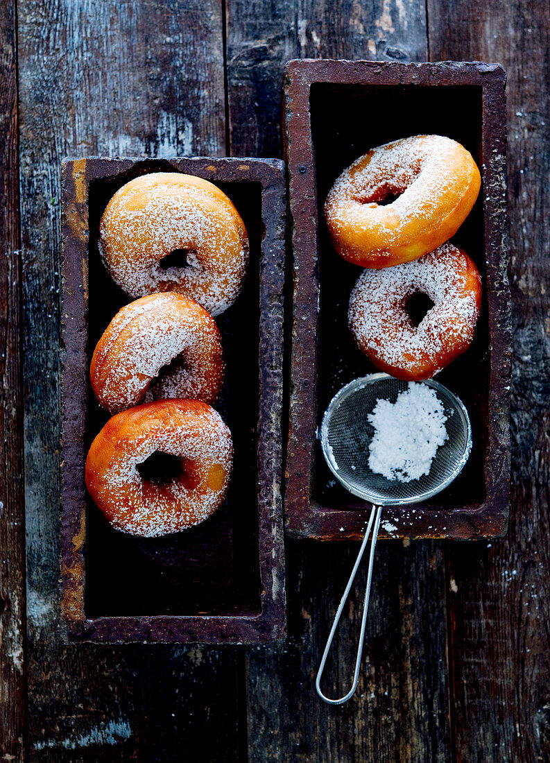 Donuts with powdered sugar and a sieve