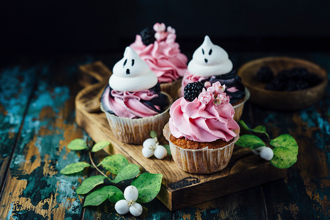 Cupcakes mit rosa Creme, Brombeeren und Baisertupfen