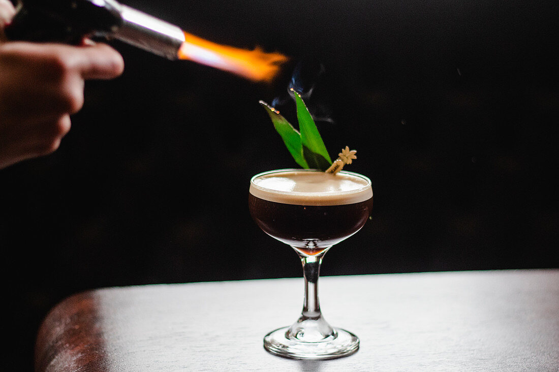 Espresso-Martini mit flambierten Pandanblättern