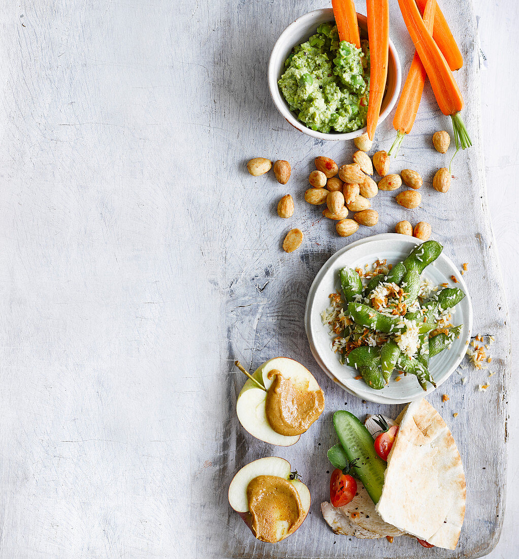 Gesunde Snacks - Erbsen-Minz-Dip mit Karottensticks, Pita-Taschen und gebratene Edamame