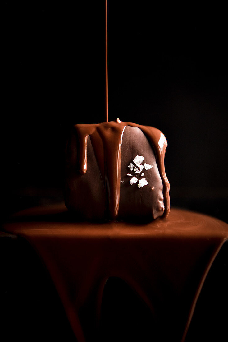 Schokolade fließt auf Mini-Schokoladenkuchen