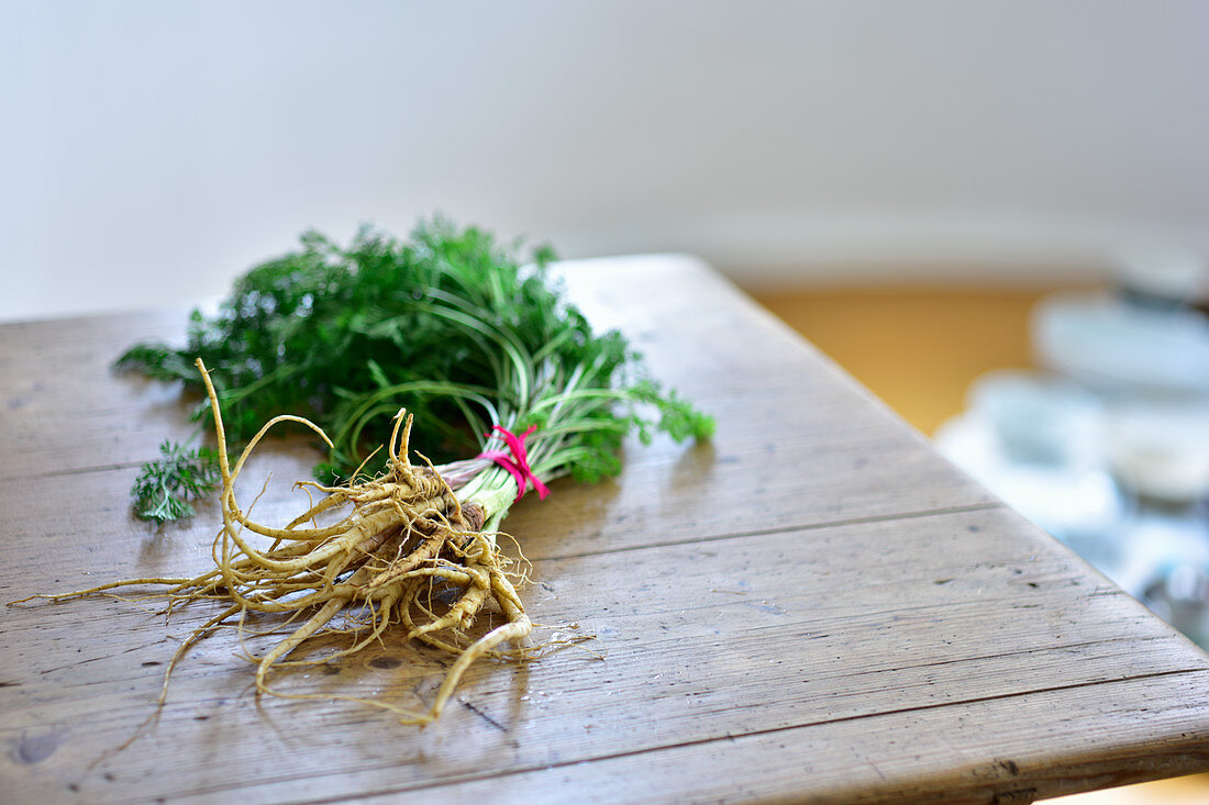 A bunch of wild carrots on a wooden table