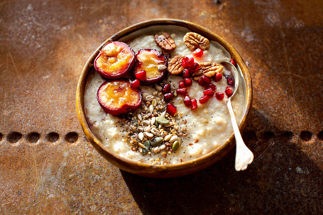 Porridge with plums, pecan nuts and pomegranate