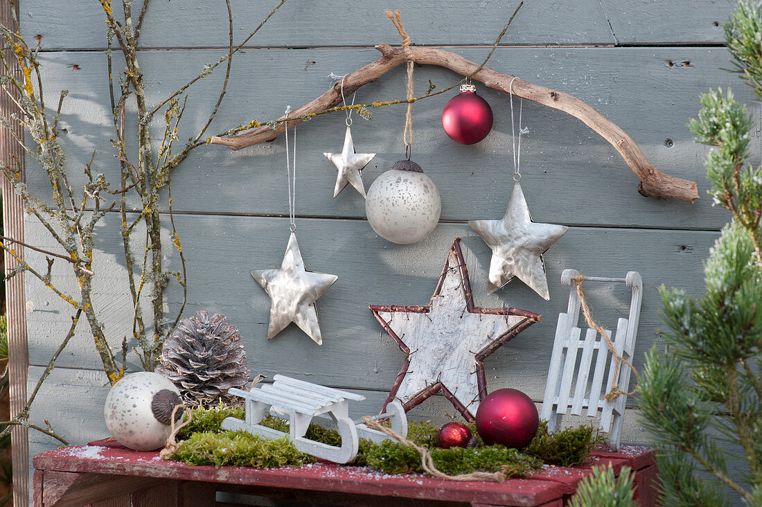 Christmas decoration with stars, balls, twigs, cones, moss and sledge
