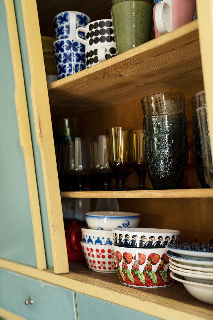 Old crockery and glasses in mid-century-modern kitchen cabinet
