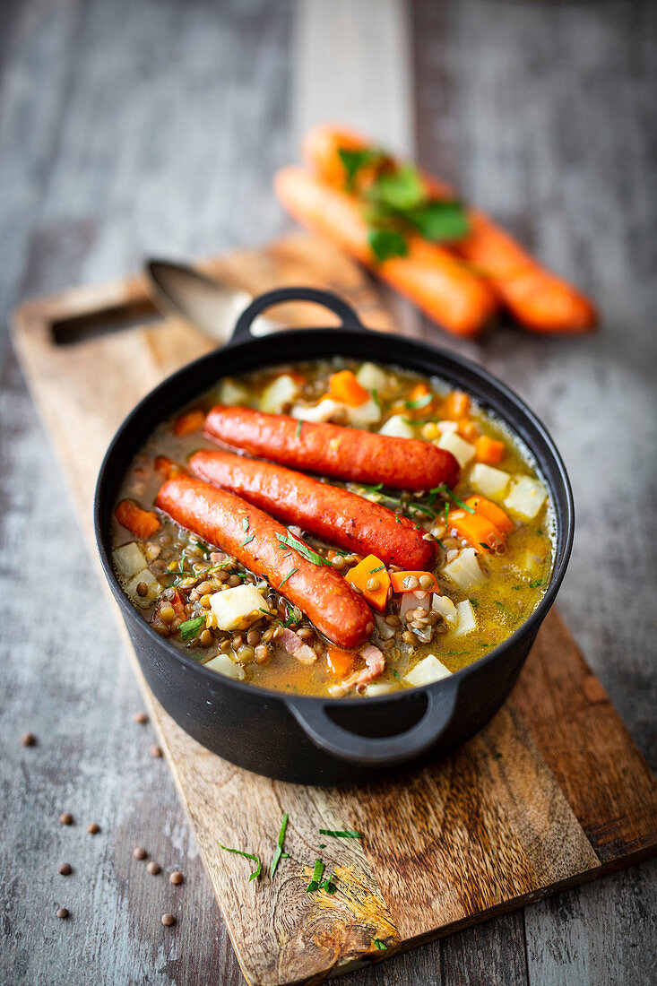 Lentil stew with bacon and cooked sausages