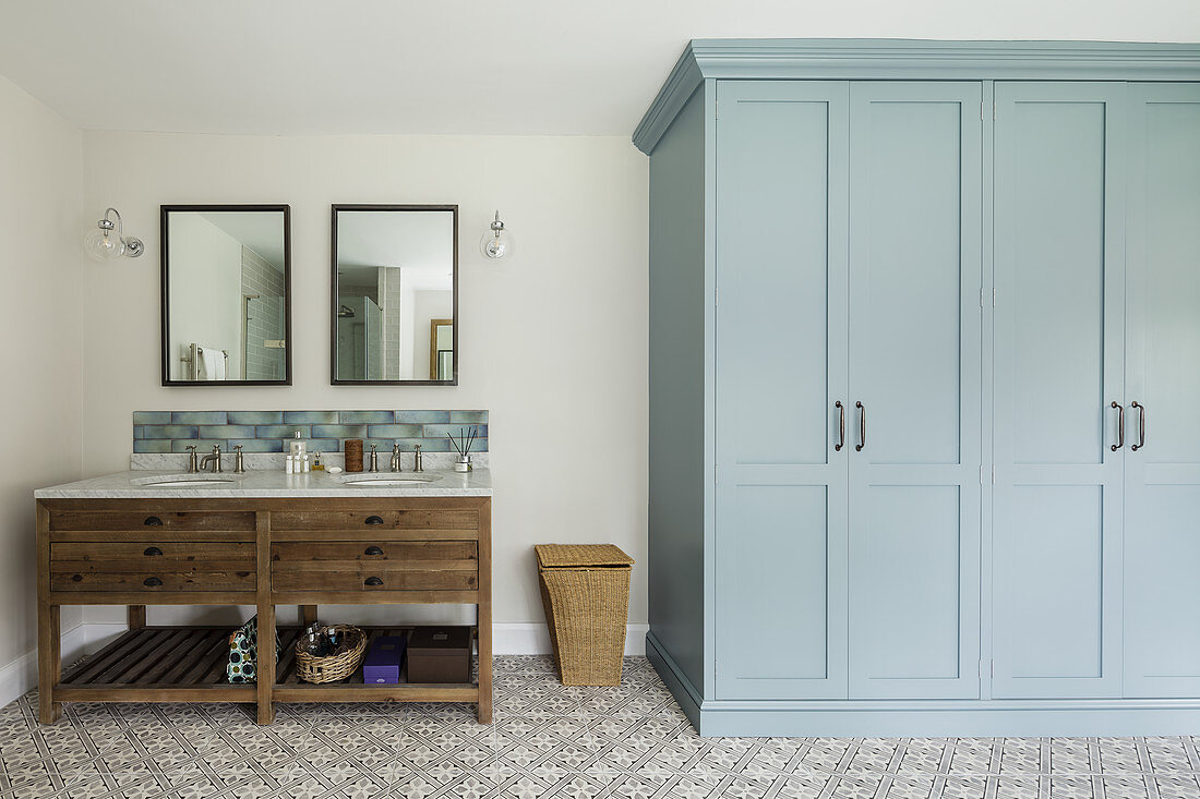 Twin sinks on washstand and grey cupboard in bathroom