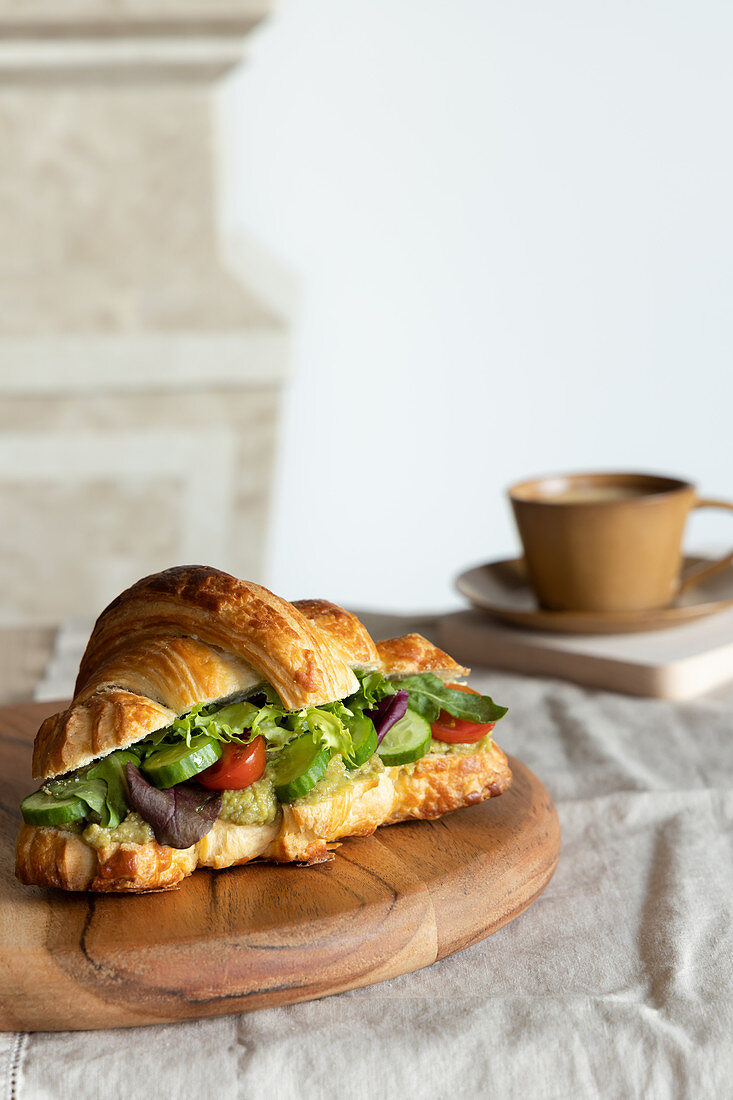 Croissant-Sandwich mit frischen Gurken und Salat zum Frühstück