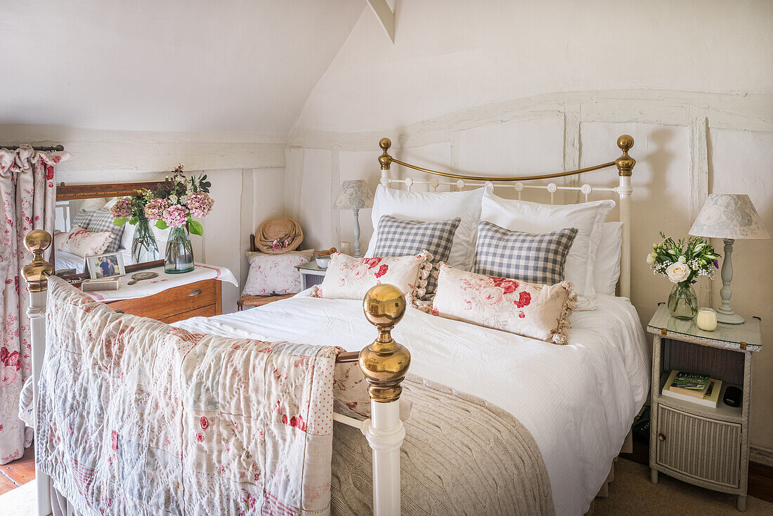 Patchwork quilt made from remnants of favourite fabrics, on wrought iron bed