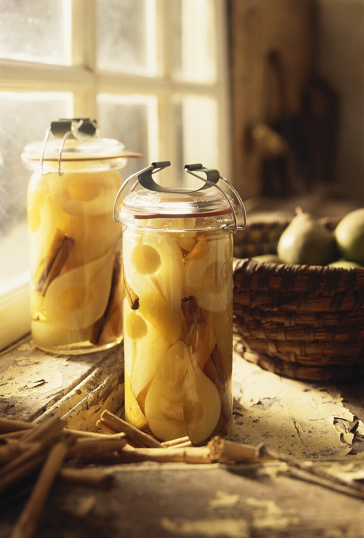 Two jars of bottled pears in front of kitchen window