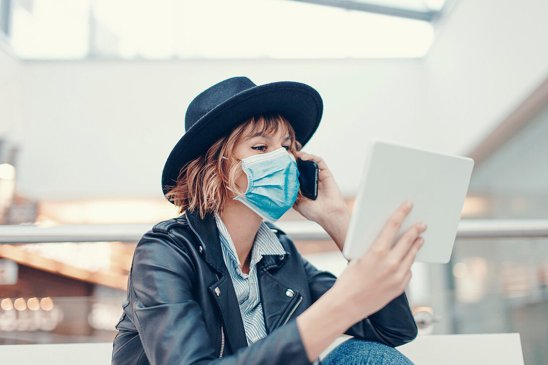 Busy woman in face mask making phone call