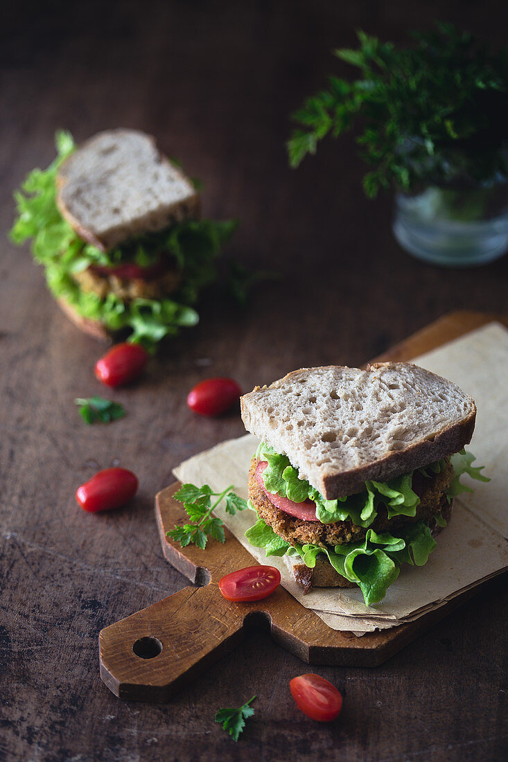 Sandwich mit Kichererbsenburger, Salat und Tomaten