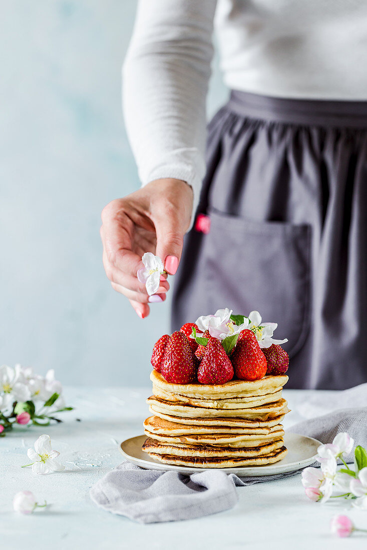 A stack of pancakes decorated with fresh strawberries