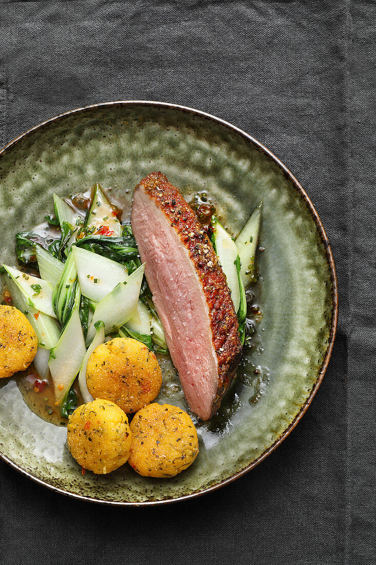 Marinated duck breast with bok choy and corn cakes (Jamaica)