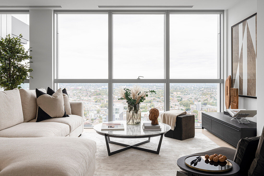 Modernes Wohnzimmer in gedeckten Farben mit Blick über die Stadt