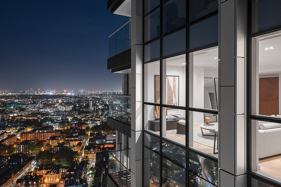 Living room in a modern high-rise building in a city that is illuminated at night