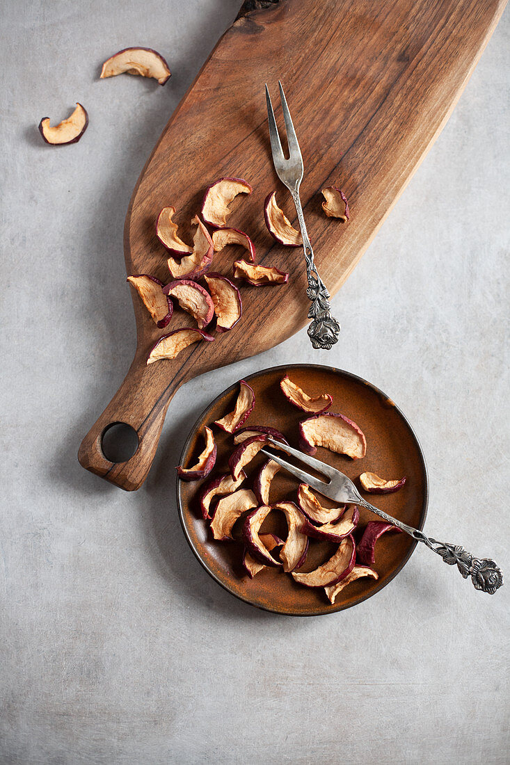 Dried apple slices on a plate and a wooden board