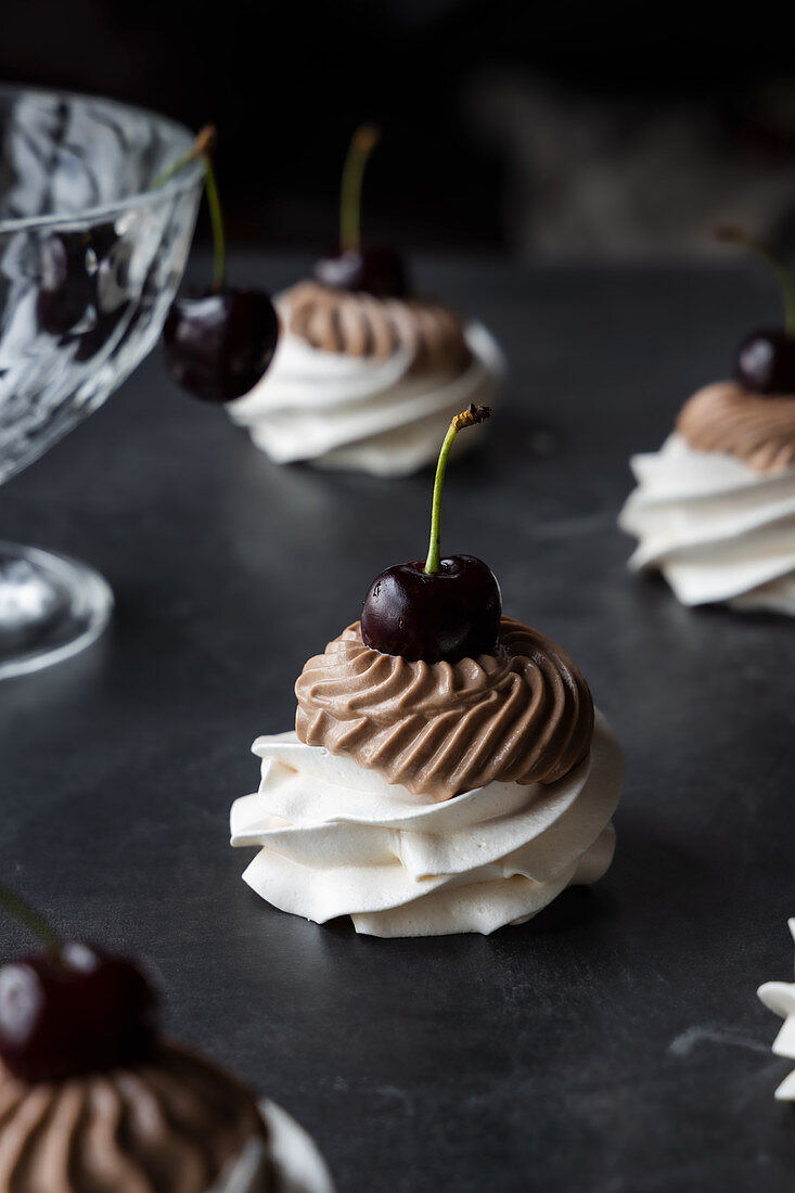 Mini-Pavlovas mit Schokoladencreme und frischer Kirsche