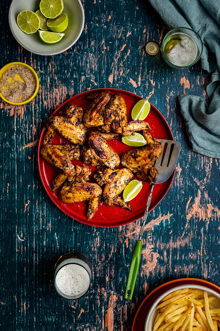 Chicken Wings serviert mit Pommes und Bier