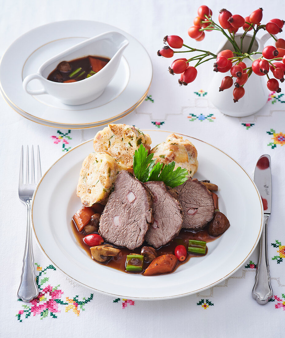 Veal leg roasted on bacon with rosehip sauce and dumplings