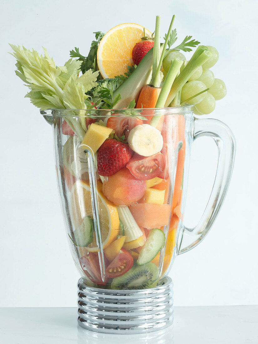 A blender full of fresh vegetables and fruit