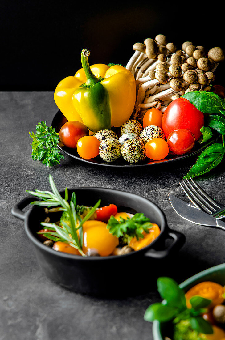 Gemüsesalat mit Tomaten und Pilzen, garniert mit Basilikum und Rosmarin (Zutaten für Baked Eggs)