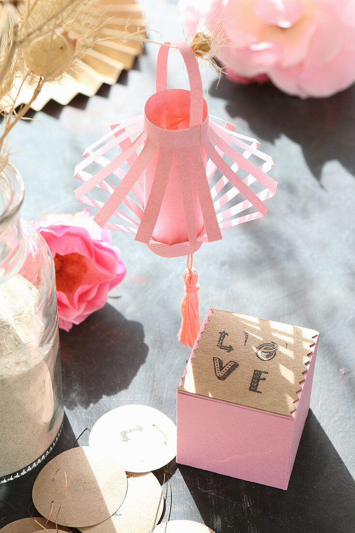 Pink paper lantern and cube labelled 'Love' in sunshine